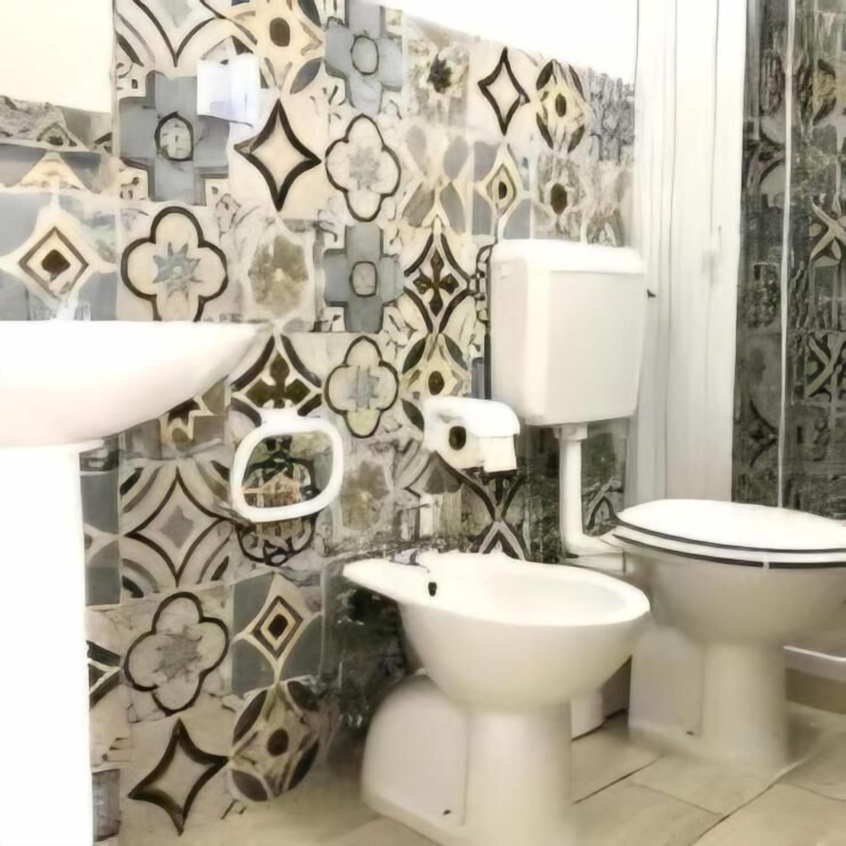 A bathroom with a toilet, bidet, and sink.