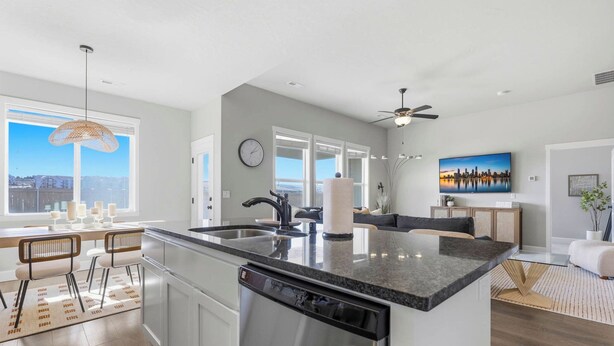 A modern kitchen with a large island, stainless steel appliances, and a dining area with bar stools. - Haven in the Desert - Kennewick spacious home (Kennewick)