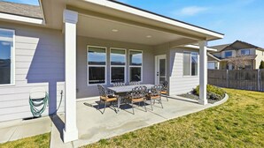A residential house with a covered patio, a lawn, and a visible garden hose. - Haven in the Desert - Kennewick spacious home (Kennewick)
