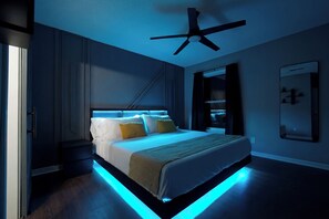 A modern bedroom with a bed, bedside tables, a ceiling fan, and a nightstand. - Premium Townhome #A w/ 2 King Beds & Luxury Baths (Peachtree Corners)