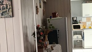 A kitchen with a wooden counter, a refrigerator, a coffee maker, and a small island with a lamp and decorative items. - Logement très spacieux.portail un code digital.bte à clé. Animals refused. (Dangé-Saint-Romain)