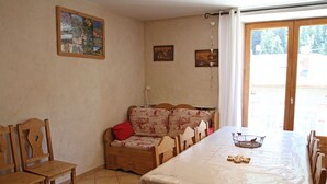 Un comedor con una larga mesa, sillas, un sofá y una pared decorada con cuadros.