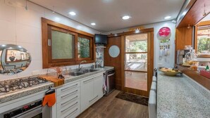 Uma cozinha moderna com bancadas de granito, fogão a gás, armários brancos e uma janela ampla.