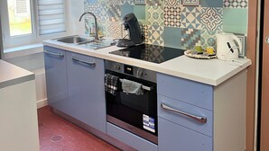 A compact kitchen with a built-in oven, a coffee maker, and a sink. - Quiet apartment in the heart of the Cours Julien (Marseille)