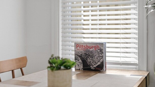 Ein Esstisch mit einem Buch mit dem Titel 'Pittsburgh' und einem Blumentopf.