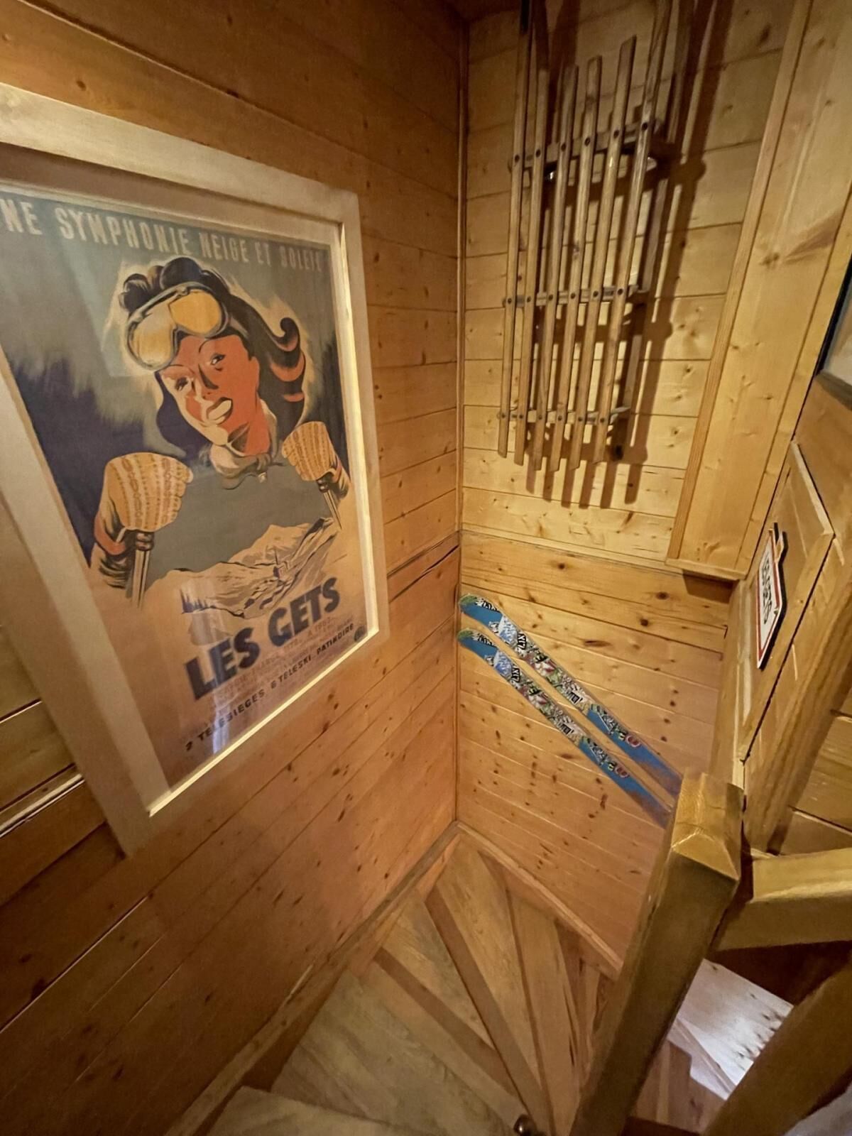 Et trægulvsrum med et plakat, en trætrap og et sæt trætrapper.
