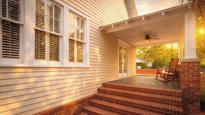 A house with a porch, steps, and a ceiling fan.