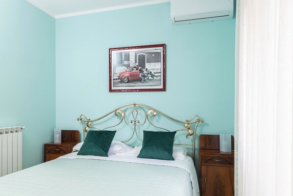A bed with a headboard, two pillows, a nightstand, a radiator, and a framed picture on the wall. - Sorrento in vista, just a few steps from town center (sorrento)