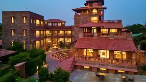 A multi-story building with a courtyard, stone walls, and a red-tiled roof. - Seraibagh Ranthambore (Sawai Madhopur)