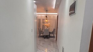 Ein Korridor mit Marmorboden, der in einen Essbereich mit Tisch und Stühlen führt.