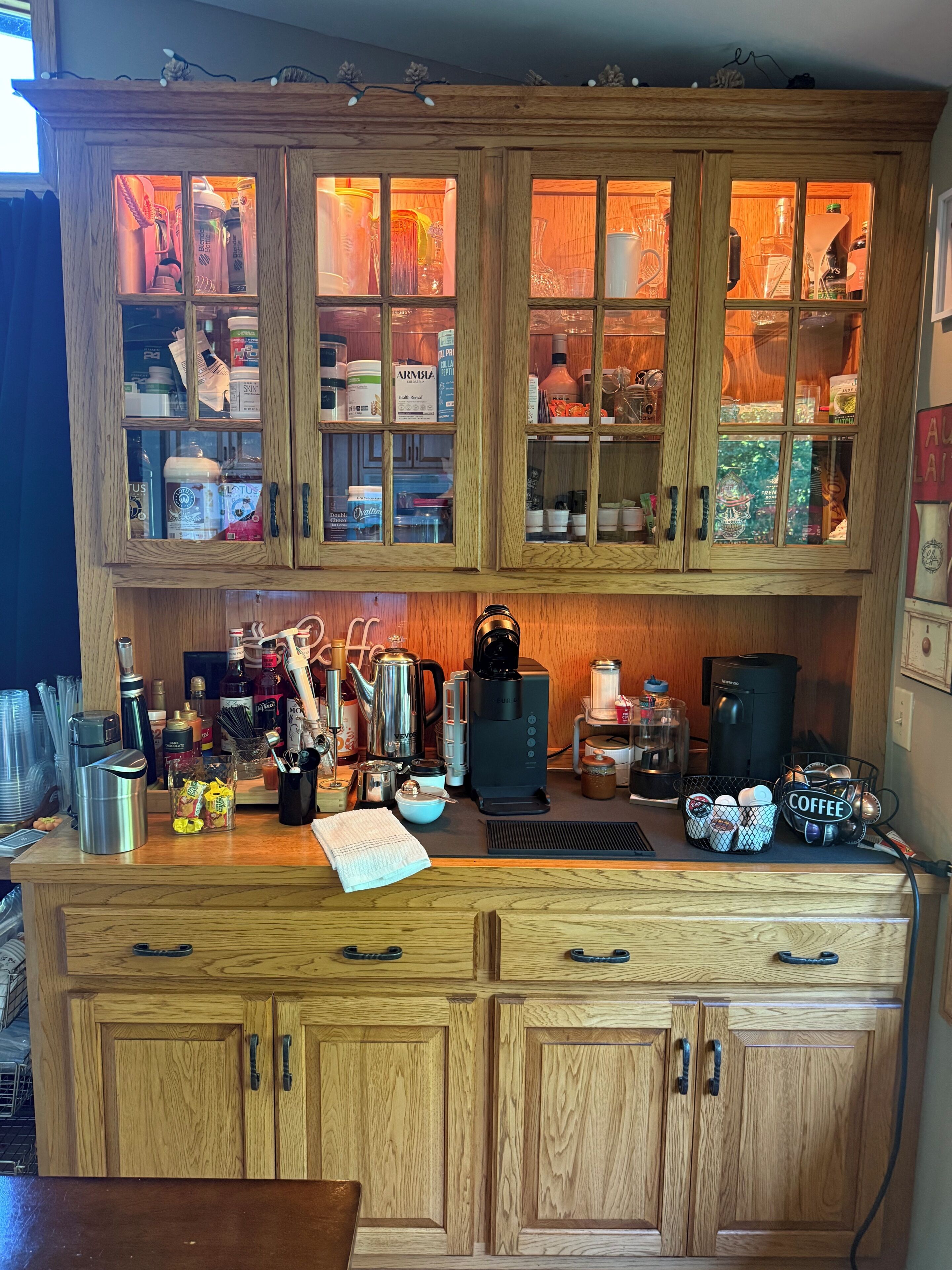 A wooden kitchen with cabinets, a coffee maker, and various kitchen utensils.