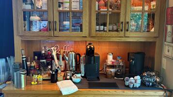 A wooden kitchen with cabinets, a coffee maker, and various kitchen utensils.