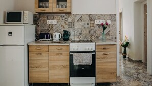 A kitchen with a microwave, toaster, kettle, and oven. There are wooden cabinets and a tiled backsplash. - Cozy vacation house near Lake Balaton in Vonyarcvashegy (Vonyarcvashegy)