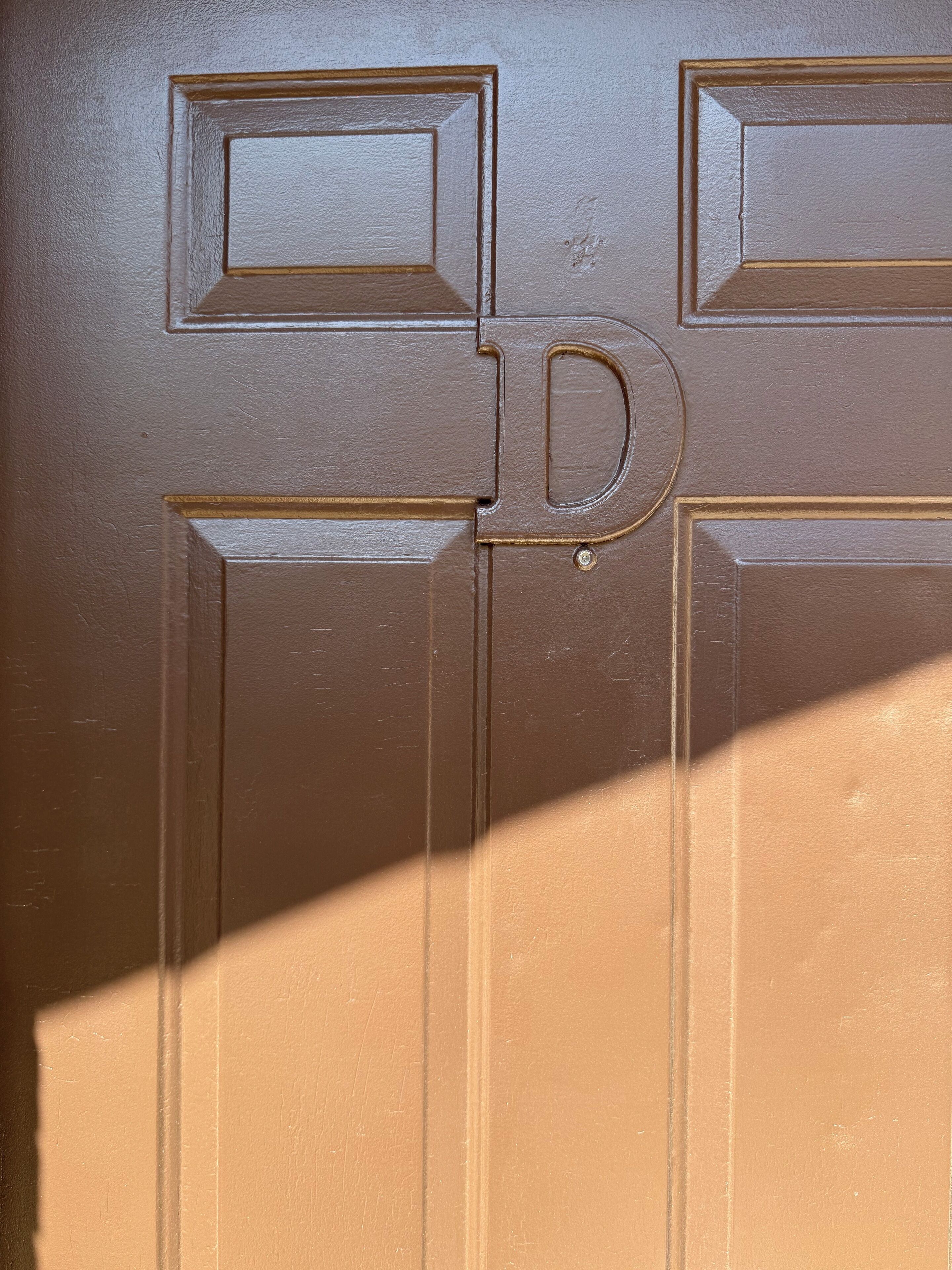 Une porte dotée d’un panneau rectangulaire et d’une poignée ronde.