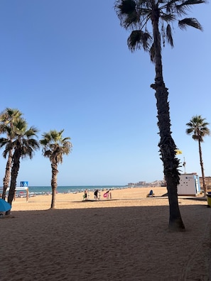 A beach with palm trees, a clear sky, and a few people in the distance. - 70-square-meter house / sleeps 6 / 50-meter community pool (Torrevieja)