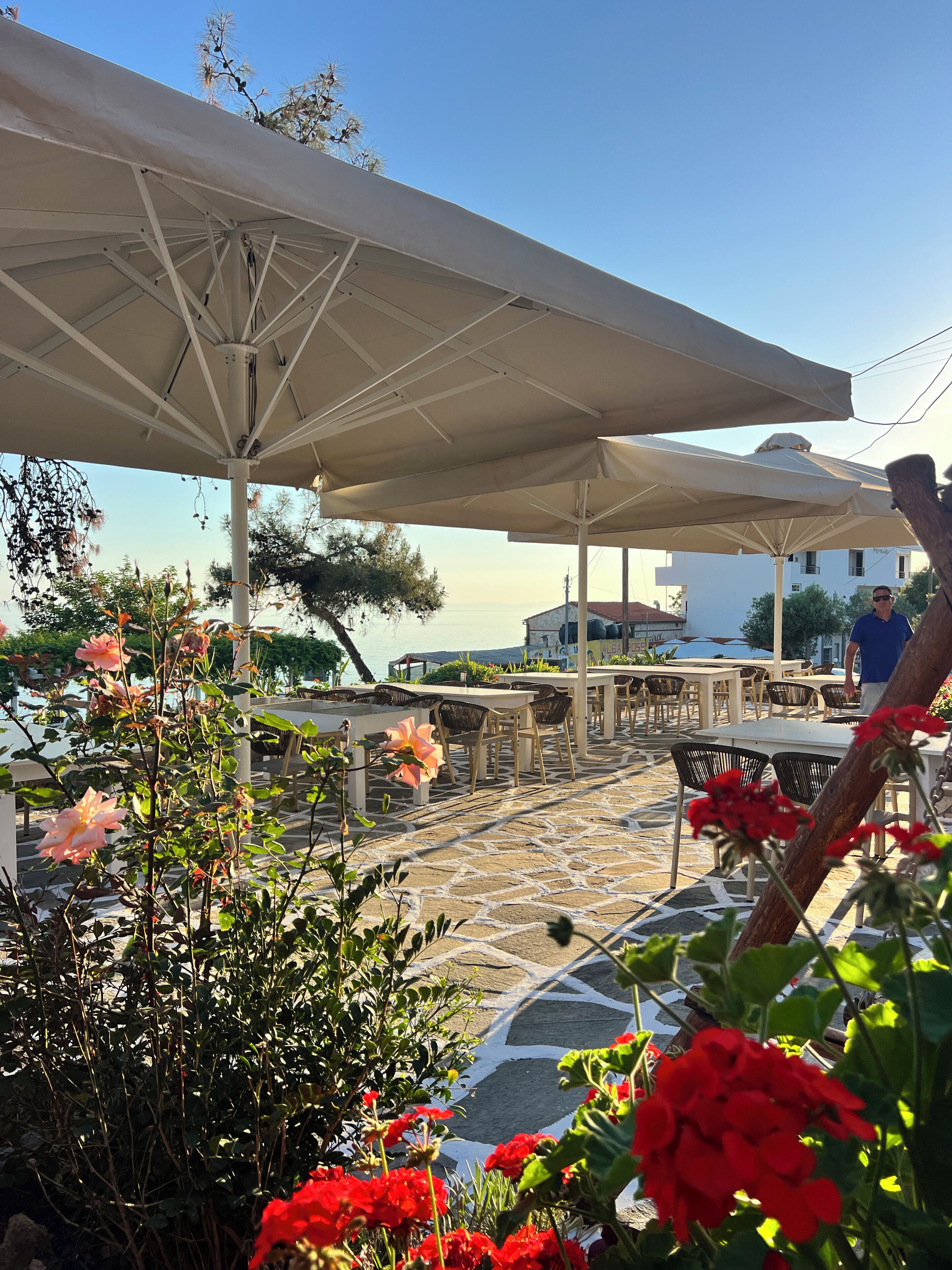 An outdoor seating area with umbrellas, tables, and chairs.