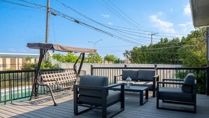 A deck with outdoor furniture, a pergola, and a pool. - Havre d'Abraham residence (Laval)