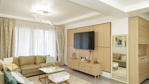 Ein modernes Wohnzimmer mit Sofa, Couchtisch, Fernseher und Kleiderschrank.