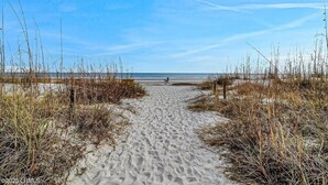 A sandy beach path with tall grasses on either side, leading to the ocean. - Steps to the Surf! Top-Floor Condo w/Stunning Ocean View! (Hilton Head Island)