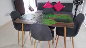 A dining table with four chairs, a wooden surface, and a leaf-patterned table runner. - Apartasol La Tebaida, Quindío (La Tebaida)