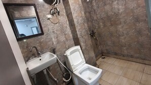 Een badkamer met een wastafel, toilet en douche.