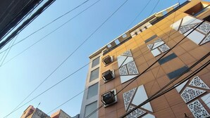 Een meerhoog gebouw met een bordje voor 'OM Bath Concepts', wat wijst op een service voor design wand- en vloertegels.