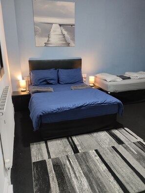 A bedroom with a bed, bedside tables, a lamp, and a wall-mounted picture. - Hotel Vibes (Blackpool)