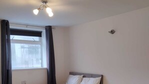 Une chambre à coucher moderne avec un lit, un canapé et une table basse.