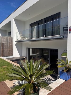 A modern two-story house with a balcony, large windows, and a well-maintained garden with palm plants. - Private Villa with Heated Pool, Jacuzzi & Garden | July–October Rental Cascais (Cascais)