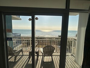 A balcony with a view of the ocean, a table, and two chairs. - COSTAL VIBES/GREAT LOCATION (Myrtle Beach)