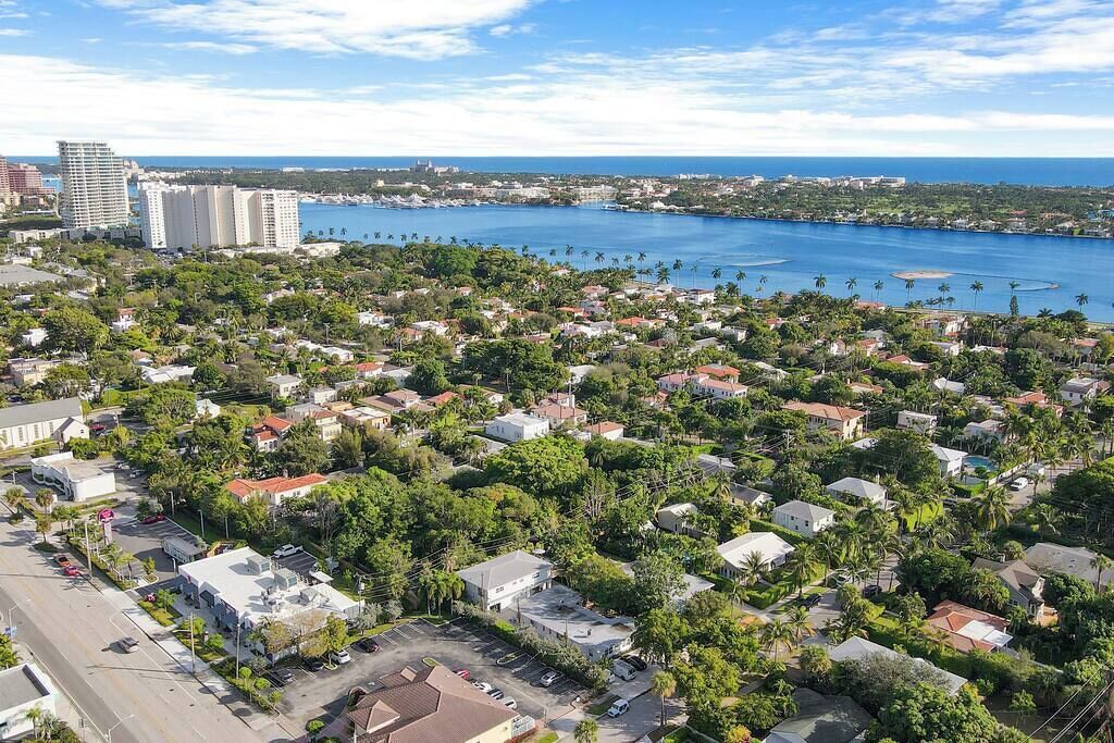 Ett flygbildsbild av ett bostadsområde vid kusten med hus, vägar och en småbåtshamn.
