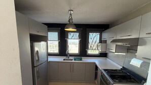 Una cocina moderna con electrodomésticos de acero inoxidable, una ventana y vistas a la ciudad.