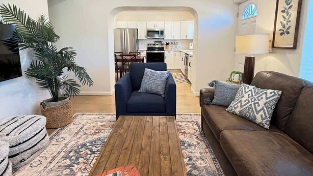 Een woonkamer met een salontafel, bank en plafondventilator.