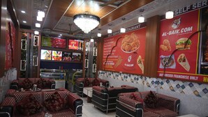 A restaurant interior with booths, tables, and a menu board.