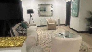 A modern living room with a white sofa, a round coffee table, and a ceiling fan. - Bobby Rush Inn 3 bedroom 1.5 Bath modern house (Jackson)