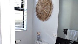 Ein Badezimmer mit Toilette, Waschbecken und Spiegel.