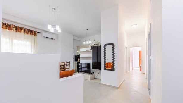 Un intérieur moderne comprenant une cuisine, un coin repas et un couloir menant à une autre pièce.