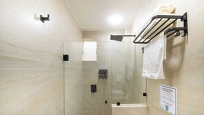 A glass-enclosed shower with a towel rack and a sign on the wall. - Hotel Puerta Gala 2903 (Guadalajara)