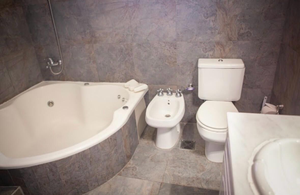 A bathroom with a bathtub, a bidet, and a toilet.
