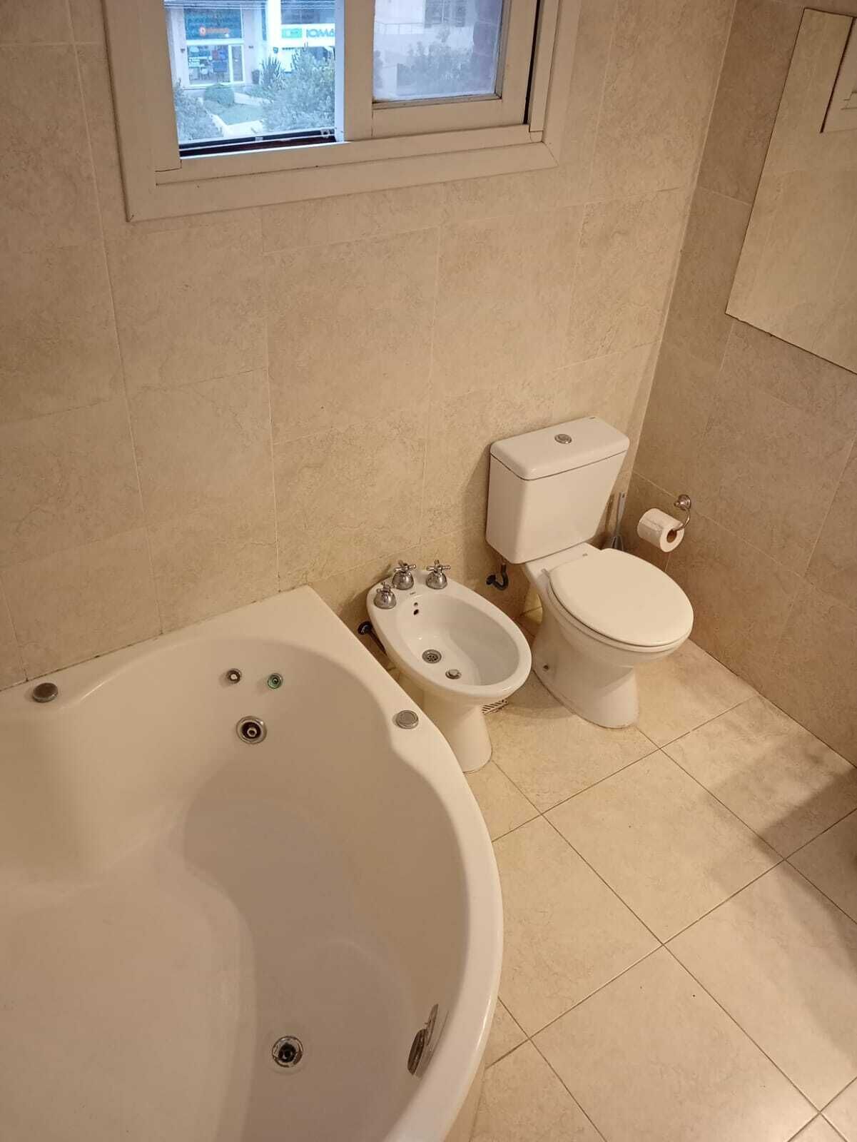 Un baño con bañera, bidé e inodoro.