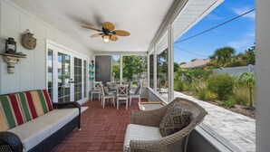 A covered patio with wicker furniture, a ceiling fan, and a view of the outdoors. - Serene 3-bedroom house with AC in charming Venice (Venice)