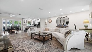 A modern living room with a sectional sofa, a glass coffee table, and a patterned rug. - Serene 3-bedroom house with AC in charming Venice (Venice)