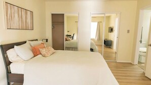Un dormitorio con una cama grande, un armario y un espejo.