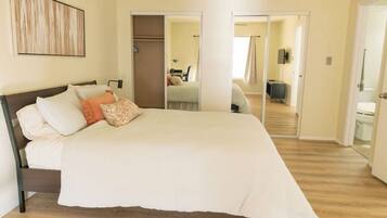 A bedroom with a large bed, a wardrobe, and a mirror.