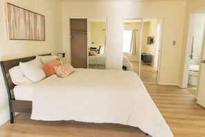 A bedroom with a large bed, a wardrobe, and a mirror. - Superb 3-bedroom condo in the heart of Tempe. (Tempe)