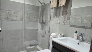 Un baño moderno con ducha, inodoro y lavabo.