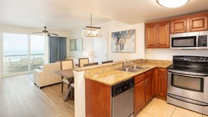 Una cocina moderna con encimeras de granito, electrodomésticos de acero inoxidable y armarios de madera.
