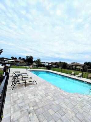 A swimming pool with lounge chairs and a tiled deck. - St. Johns Riverside Retreat, fish, boat, relax. Long stays welcome. (Astor)