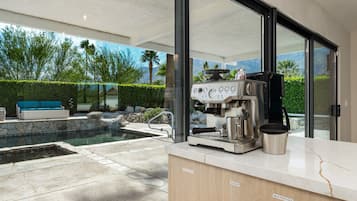 Une cuisine moderne équipée d’une machine à café, d’un mixeur et d’un plan de travail.