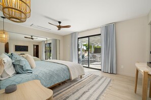 A bedroom with a bed, a ceiling fan, a large window with curtains, and a view of the outdoors. -   Casa del Sol Saltwater Pool, Fire Pit, Espresso Bar Uniquely Designed Bedrooms (Palm Springs)
